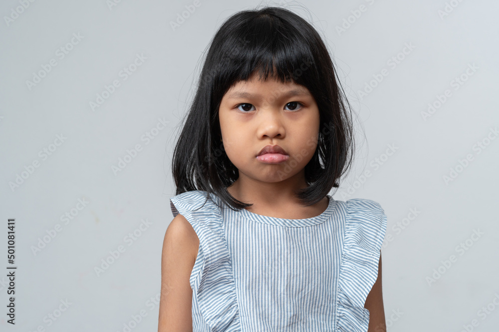 Portrait of Asian angry and sad little girl on white isolated background, The emotion of a child when tantrum and mad, expression grumpy emotion. Kid emotional control concept Portrait of Asian angry and sad little girl on white isolated background, The emotion of a child when tantrum and mad, expression grumpy emotion. Kid emotional control concept