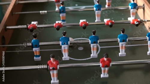 Table football, table soccer,  babyfoot, Kicker, calciobalilla or biliardino, bordfodbold, and foosball. Two young men are playing table football. photo