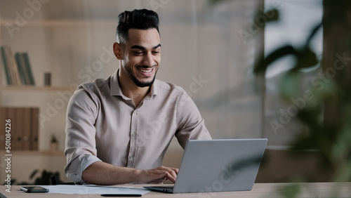 Foto Smiling happy arab man worker businessman finished task computer work relax sit