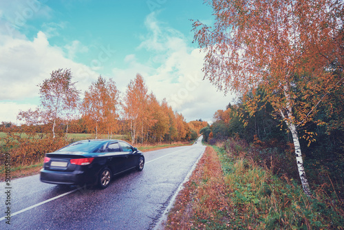 Fall season. Beautiful landscape with car on the road.