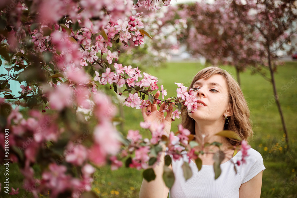 Beautiful young woman smelling blossoming apple branches in spring. Beautiful young woman smelling blossoming apple branches in spring.