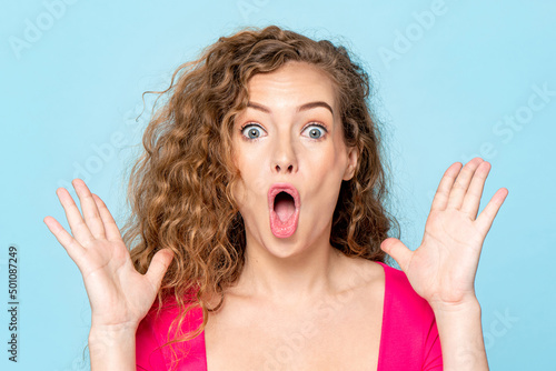 Shocked Caucasian woman screaming with open hands in isolated light blue color studio background photo