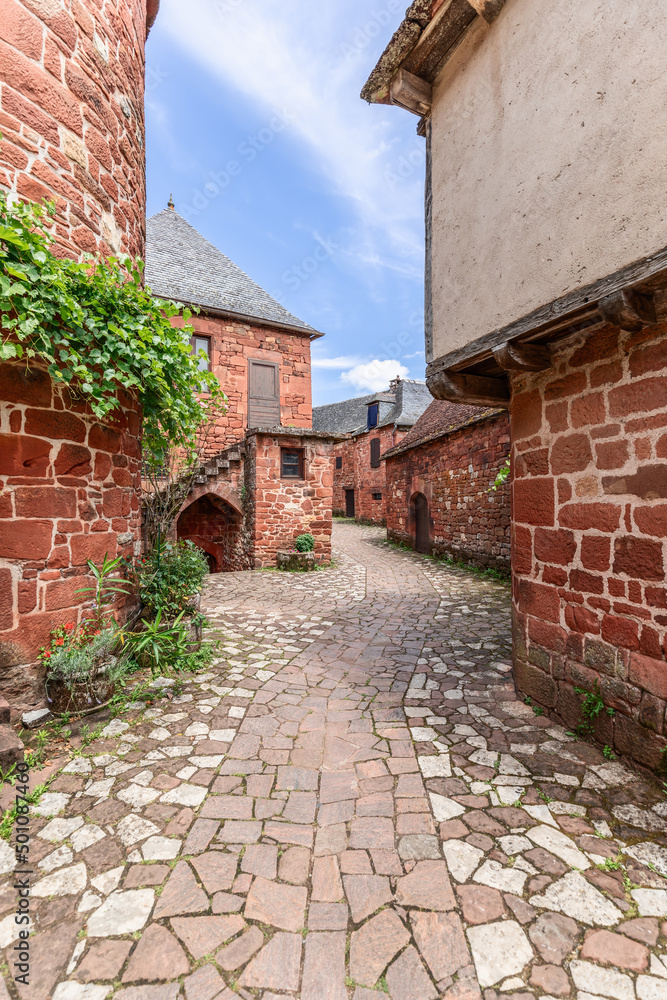 Deserted stone pavement winding between ancient red stone houses of intricate architecture in Collonges-la-Rouge, Correze department, New Aquitaine region, France