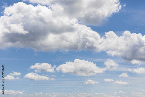 White clouds on blue sky background, cumulus clouds high on pale azure sky, beautiful aerial cloudscape view
