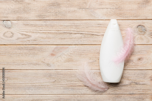 Set of skin care serums on pink pastel background with ostrich feathers. Spa cosmetic product, cream jar, branding mock up, top view with copy space photo