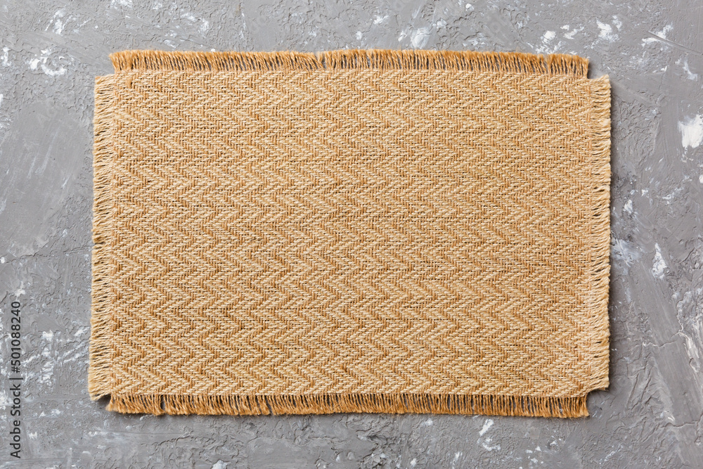 Fototapeta premium Top view of brown tablecloth for food on cement background. Empty space for your design
