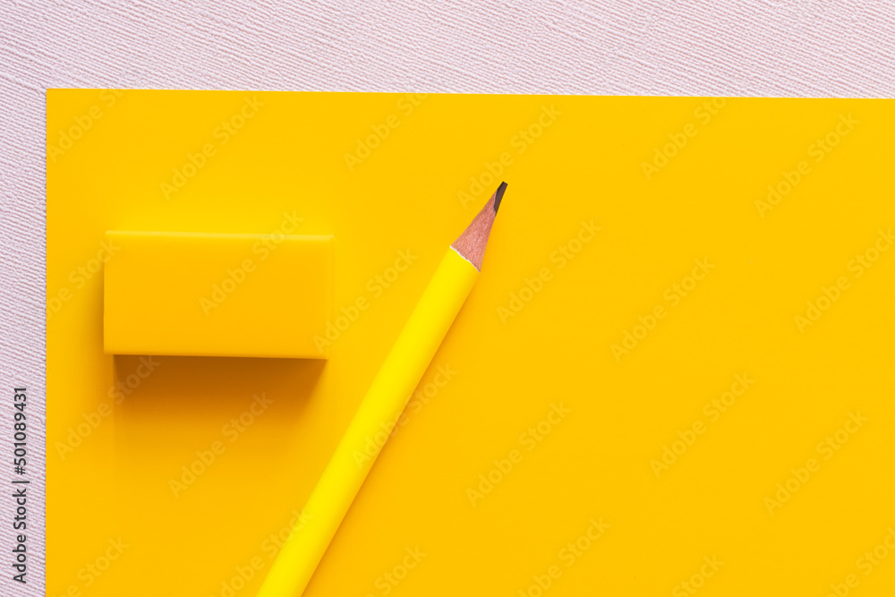 top view of pencil near eraser on yellow and white. top view of pencil near eraser on yellow and white.