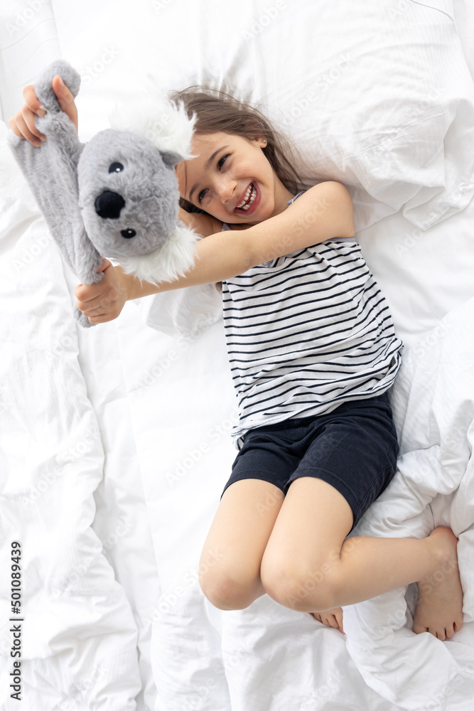 Happy little girl with soft toy koala in bed. Happy little girl with soft toy koala in bed.