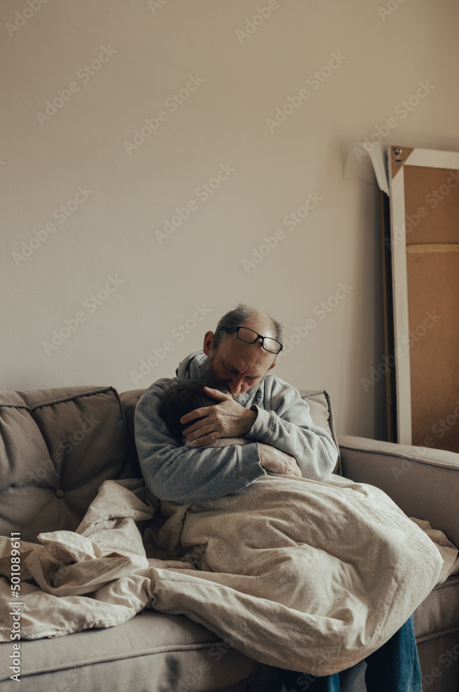 Fototapeta premium Ukrainian excited gray-haired man protects his little frightened granddaughter. Stop the war. Pray for Ukraine. We support Ukraine.