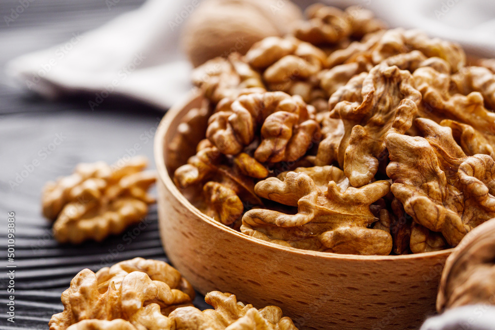 dried walnuts on a black rustic wooden background dried walnuts on a black rustic wooden background