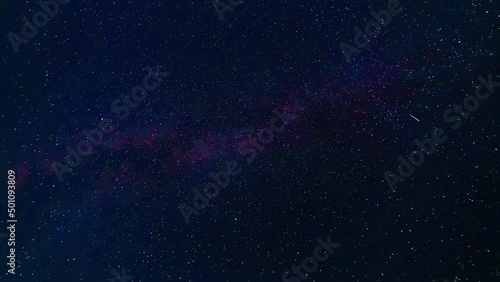 starry night blue sky with the milky way and a lot of falling multicolored shining stars