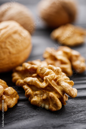 dried walnuts on a black rustic wooden background