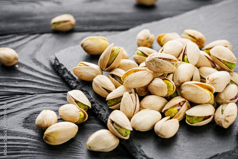 fresh salted pistachios on a black stone wooden rustic background fresh salted pistachios on a black stone wooden rustic background