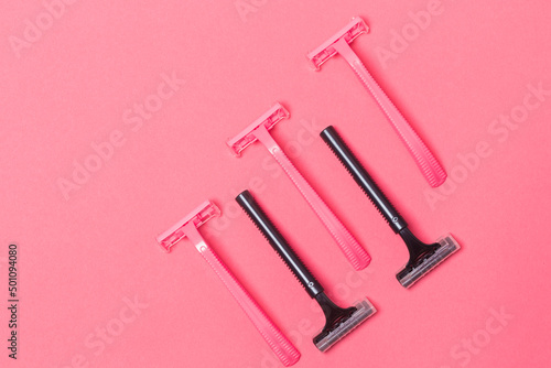 Female Hygiene Concepts. Variety of Five Colorful Pink and Black Disposable Razors Shavers Placed Together Over Trendy Pink Coral Background.