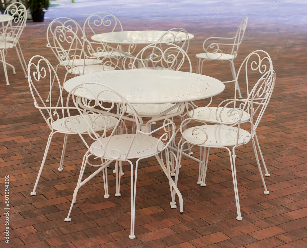 White metallic tables and chairs in summer cafe