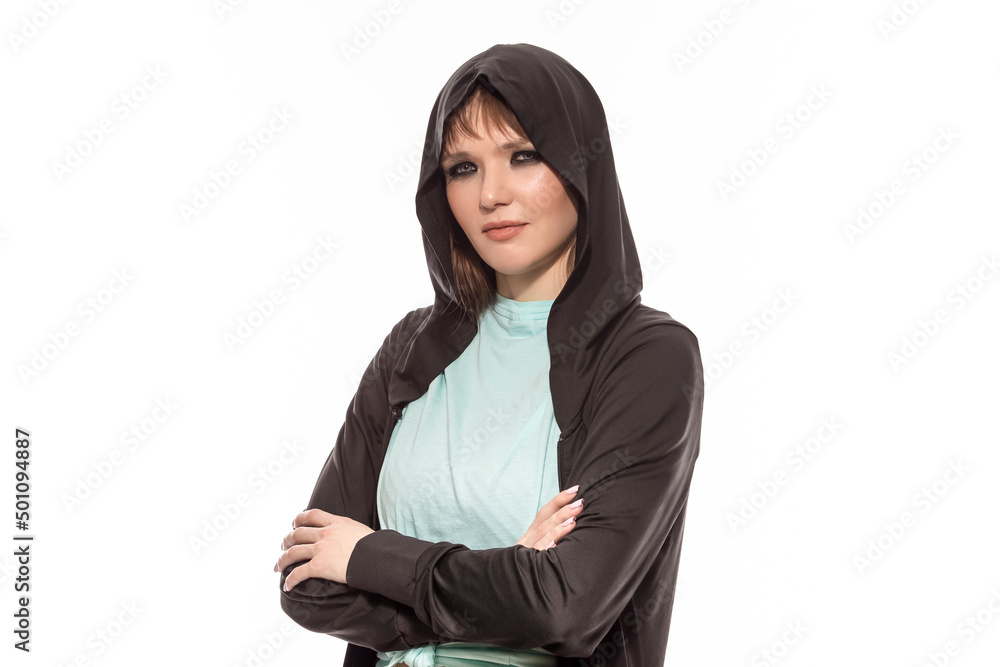 Natural Closeup Portrait of Smiling Winsome Blond Caucasian Female Athlete In Black Hoody Posing With Folded Hands While Looking Straight Against Pure White. Natural Closeup Portrait of Smiling Winsome Blond Caucasian Female Athlete In Black Hoody Posing With Folded Hands While Looking Straight Against Pure White.