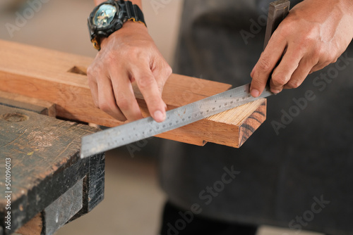 Carpenter working on wood craft at workshop to produce construction material or wooden furniture
