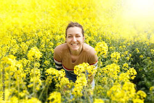 Portrait of a smiling woman in a yellow field during the summer