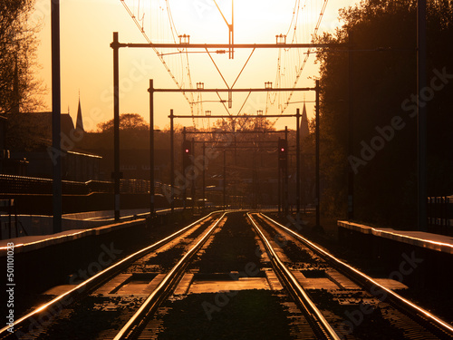Railroad track with beautiful golden sunlight backlight in Hilversum, the Netherlands