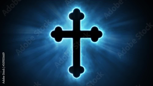 Uplifting and deeply inspiring reveal animation of an ornate and holy blue Christian crucifix cross, in a smoky mystical glow and emating shining God rays and light beams, on a black background photo