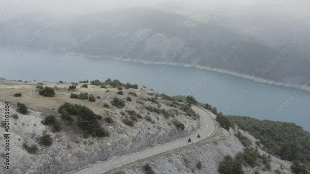 Aerial shot of two motorcycle rider driving close to a big blue lake during the winter. He is snowing at the lake of Serre-Ponçon.
Aerial shot of two motorcycle rider driving close to a big blue lake during the winter. He is snowing at the lake of Serre-Ponçon.