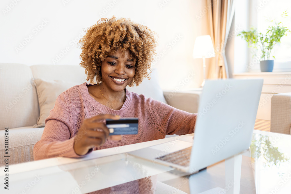 Close up smiling millennial woman holding smartphone and banking credit card, involved in online mobile shopping at home, happy female shopper purchasing goods or services in internet store.