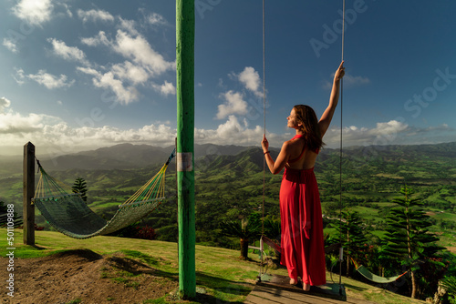 Young beautiful female model having fun on the swings at Montaña Redonda during epic sunrise 