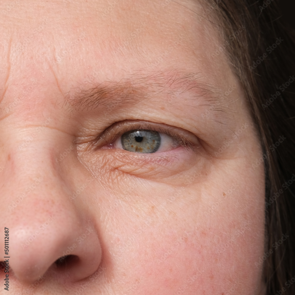 Fototapeta premium close up part of mature woman 50 years face, human eye, small wrinkles around eyes, overhang, concept of surveillance, vision examination, cosmetic anti-aging procedures