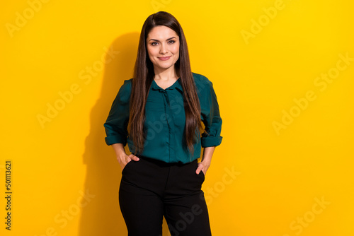 Photo of adorable cute woman wear green shirt arms hands pockets smiling isolated yellow color background