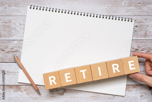 退職・引退・棄権のイメージ｜「RETIRE」と書かれた積み木、ノート、ペン、手 photo