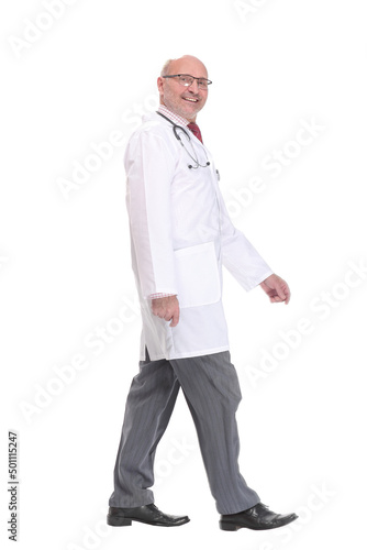 Mature doctor with stethoscope walking on white background