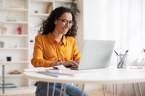 Happy Middle Eastern Businesswoman Using Laptop Sitting At Workplace