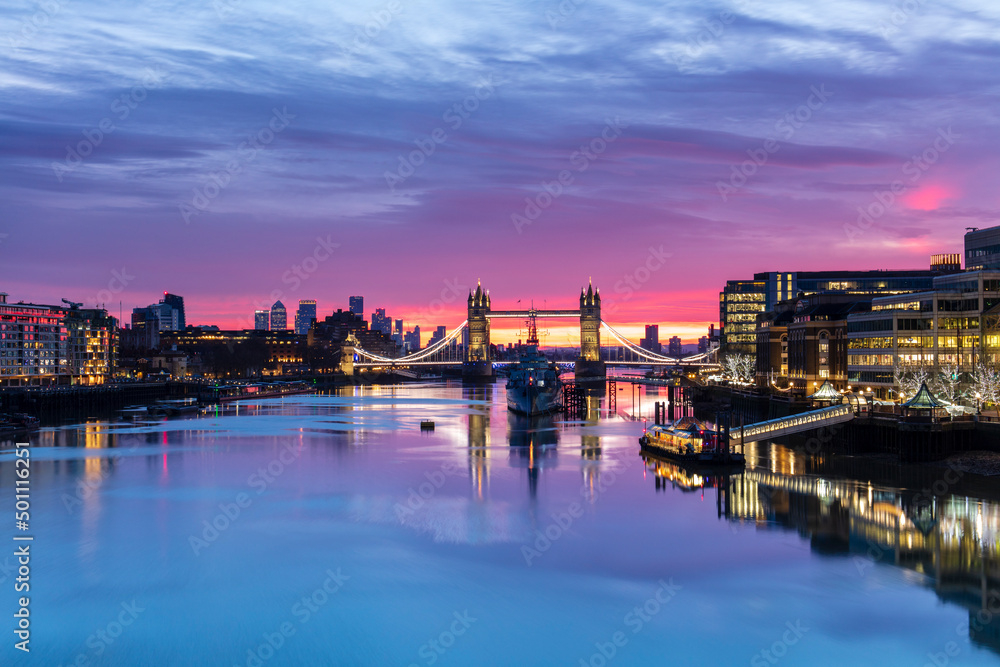 Tower Bridge and HMS Belfast reflecting in a still River Thames at sunset, London Tower Bridge and HMS Belfast reflecting in a still River Thames at sunset, London