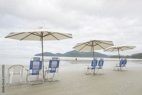 Fototapeta Naklejka Na Ścianę i Meble -  Set of Sun Chairs and Parasol on the Beach. Calm Cloud Summer Day.