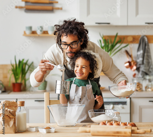 Fotografia Black man and son cooking together in kitchen