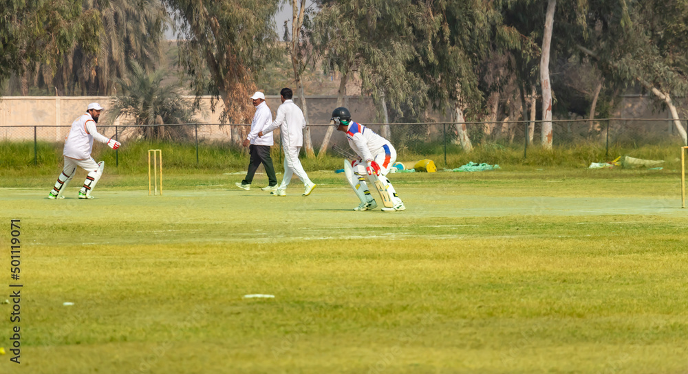 young boys playing cricket in the local city playground young boys playing cricket in the local city playground