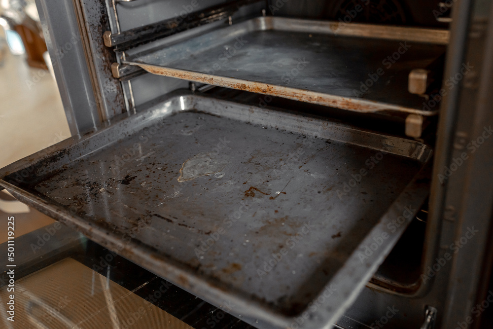 Dirty oven after cooking a greasy dish in the kitchen Dirty oven after cooking a greasy dish in the kitchen