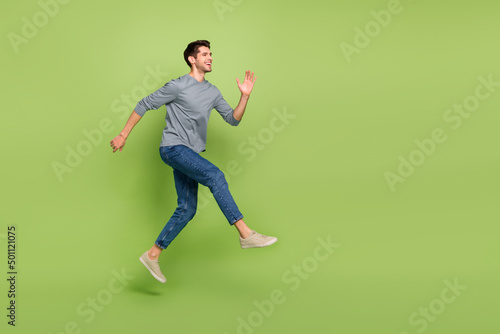 Full body photo of overjoyed emotion attractive guy excited to go on date with girlfriend isolated on green color background