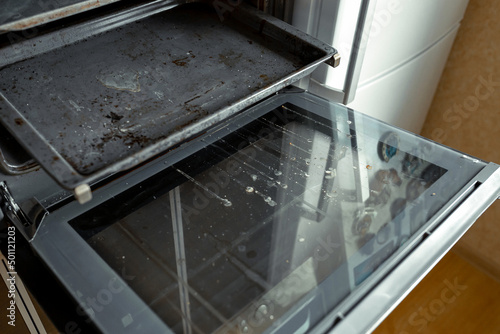 Dirty oven after cooking a greasy dish in the kitchen