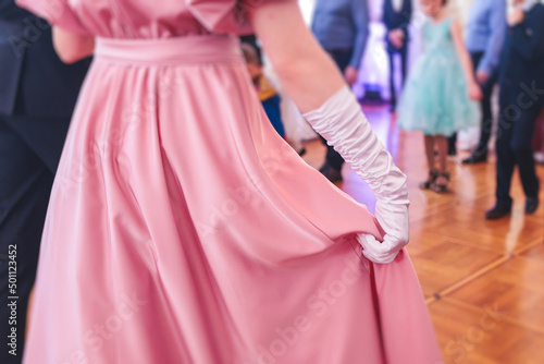 Couples dance on the historical costumed ball in historical dresses, classical ballroom dancers dancing, waltz, quadrille and polonaise in palace interiors on a wooden floor, opera gloves close-up