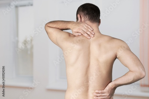 Body muscles stiff problem, attractive man, pain with back pain ache from work, holding massaging rubbing shoulder hurt.