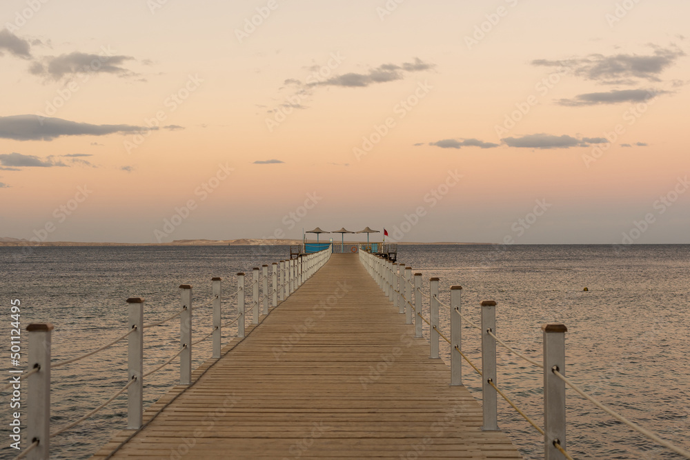 Wooden pontoon at sea, Golden sea sunset.