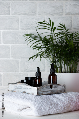 Bottles of natural cosmetic body care on a white towel. Skin care concept. photo