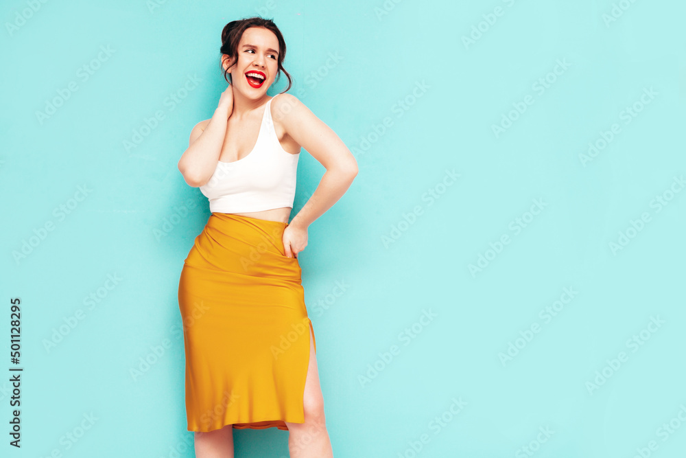 Young beautiful smiling female in trendy summer yellow skirt clothes. Sexy carefree woman posing near wall in studio. Positive model having fun. Cheerful and happy. Isolated Young beautiful smiling female in trendy summer yellow skirt clothes. Sexy carefree woman posing near wall in studio. Positive model having fun. Cheerful and happy. Isolated