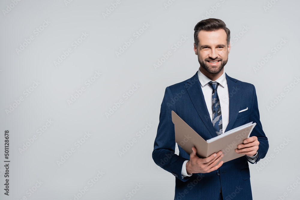 happy economist with folder smiling at camera isolated on grey. happy economist with folder smiling at camera isolated on grey.