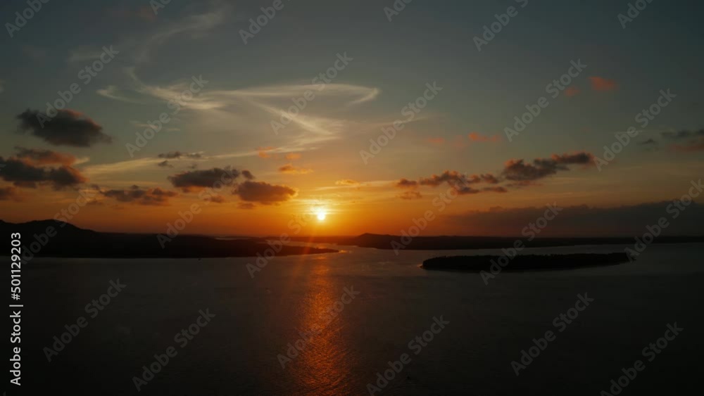Colorful bright clouds during sunset over the sea, aerial view. Reflected sun on a water surface. Sunset over ocean. Balabac, Palawan, Philippines Colorful bright clouds during sunset over the sea, aerial view. Reflected sun on a water surface. Sunset over ocean. Balabac, Palawan, Philippines