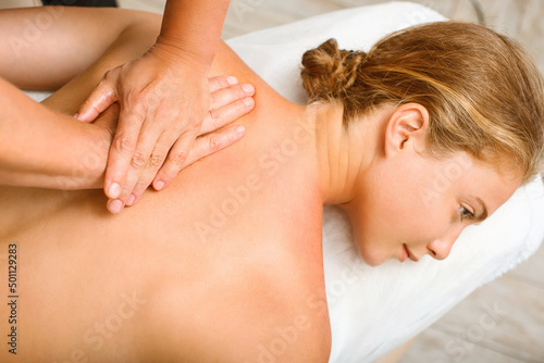 A beautiful young woman in the massage therapist's office lies on the couch.
