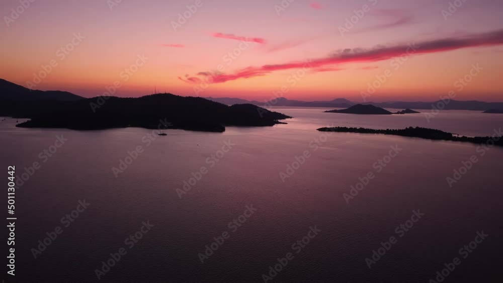 Romantic pink sunset over islands in Mediterranean sea next to the coastline filmed by drone. Landscape of the rippled water surface near a mountains shore in Turkey at twilight. Evening next to ocean Romantic pink sunset over islands in Mediterranean sea next to the coastline filmed by drone. Landscape of the rippled water surface near a mountains shore in Turkey at twilight. Evening next to ocean