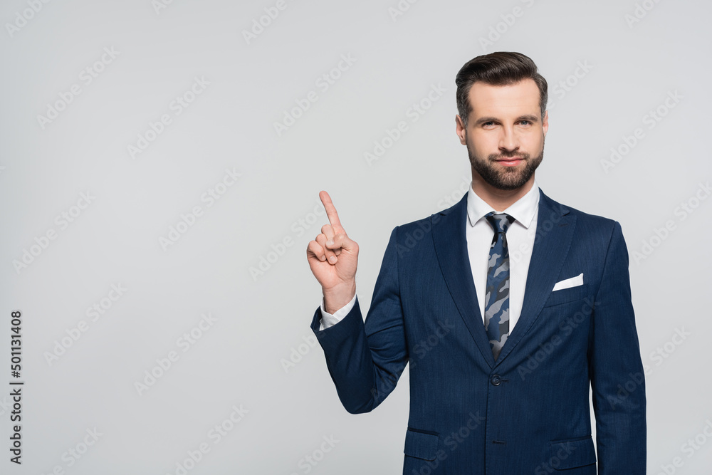 brunette businessman looking at camera and pointing with finger isolated on grey. brunette businessman looking at camera and pointing with finger isolated on grey.