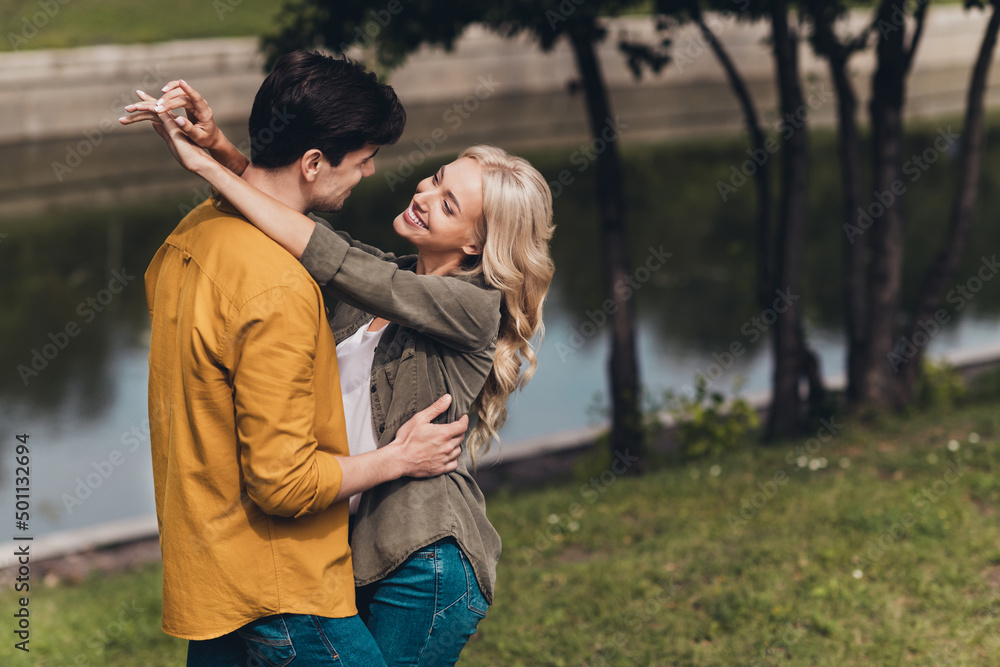 Profile side view of attractive cheerful tender sweet couple cuddling resting going on trip journey free time on fresh air outdoors Profile side view of attractive cheerful tender sweet couple cuddling resting going on trip journey free time on fresh air outdoors